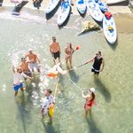 un gruppo in acqua a Riva Fiorita, unisce le pagaie come moschettieri mostrando spirito di squadra