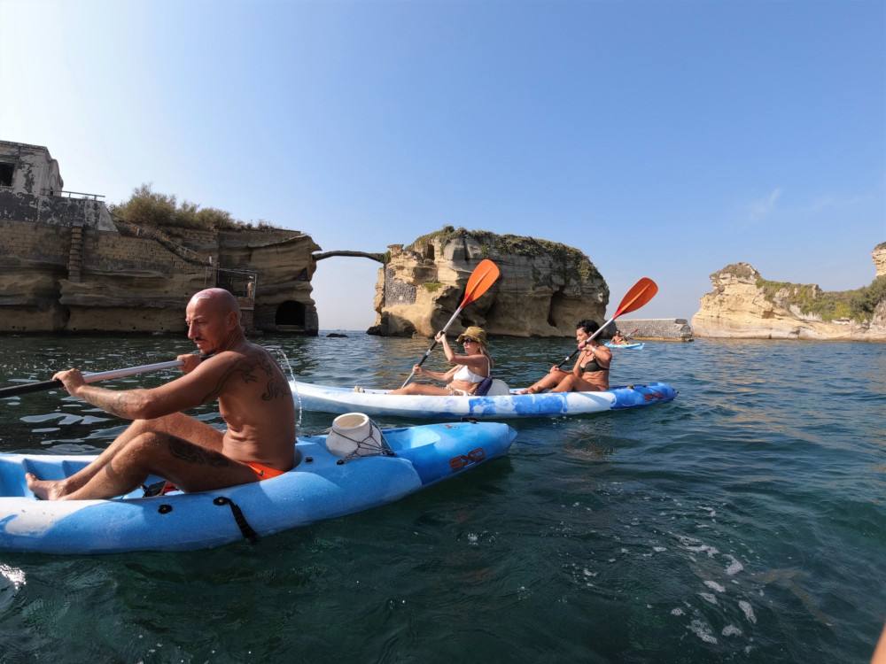 Tre persone in kayak attraversano l'aria marina protetta di Gaiola